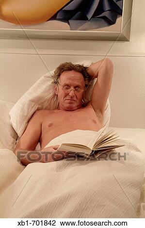 Middleaged man is reading a book in bed View Large Photo Image Stock Image - Middleaged man is reading a book in bed. Fotosearch