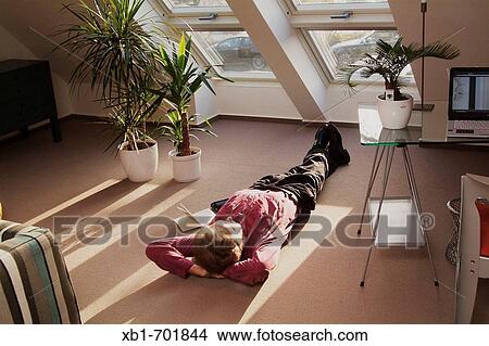 Middleaged man is relaxing on the floor View Large Photo Image Picture - Middleaged man is relaxing on the floor. Fotosearch