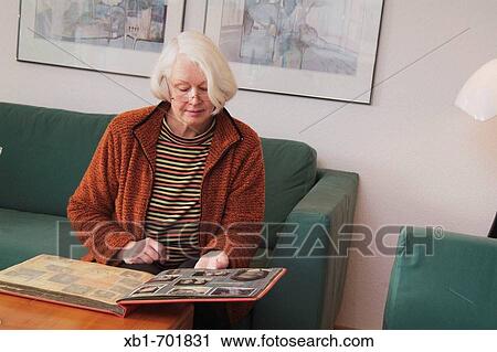 Middleaged woman is looking at photo album View Large Photo Image Stock Image - Middleaged woman is looking at photo album. Fotosearch