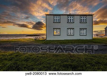 Stock Image - Midnight sun over house on Flatey Island, Borgarfjordur, Iceland.. Fotosearch