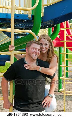 Midwest couple aged 22 playing and dating in park at monkey bars and hugging playing View Large Photo Image Stock Image - Midwest couple aged 22 playing and dating in park at monkey bars and hugging playing. Fotosearch