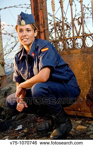 Military girl posing with a spike fence in background View Large Photo Image Stock Photograph - Military girl posing with a spike fence in background. Fotosearch