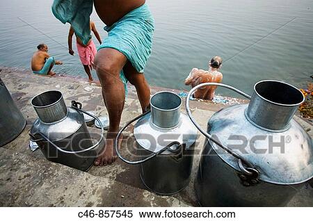 Stock Photography - Milk cans on the ghats of Ganges river, Varanasi. Uttar Pradesh, India. Fotosearch