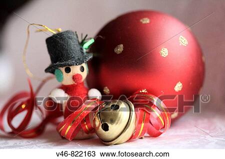 Stock Image - Miniature snowman, red Christmas ball and jingle bell with curled ed and gold ribbon. Fotosearch