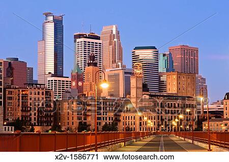 Stock Image - Minneapolis skyline at dawn as seen from the Stone Arch Bridge. Fotosearch