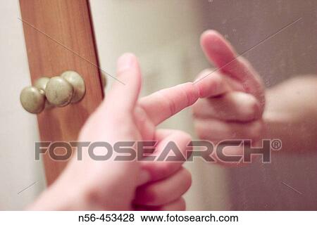 Stock Photo - Mirror image of hand shooting. Fotosearch