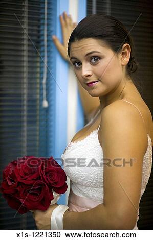 Stock Image - Model posing in white satin wedding gown. Fotosearch