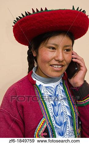 Stock Photo - Modern life in Peru woman in traditional dress and hat with cell phone communicating via wireless. Fotosearch