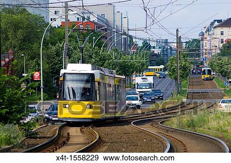 Modern trams on the streets of the former East Berlin with busy traffic View Large Photo Image Stock Photo - Modern trams on the streets of the former East Berlin with busy traffic. Fotosearch