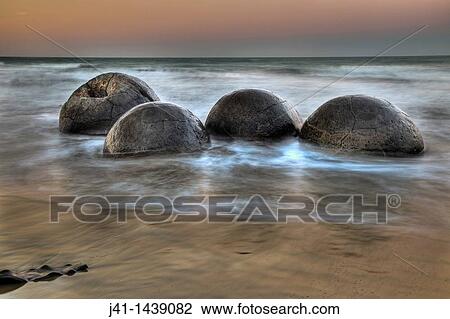Moeraki boulders at dusk, alpenglow over Pacific Ocean, near Oamaru, Otago, New Zealand View Large Photo Image Stock Image - Moeraki boulders at dusk, alpenglow over Pacific Ocean, near Oamaru, Otago, New Zealand. Fotosearch