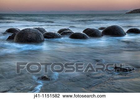Moeraki boulders at dusk, glow over Pacific Ocean, near Oamaru, Otago, New Zealand View Large Photo Image Stock Image - Moeraki boulders at dusk, glow over Pacific Ocean, near Oamaru, Otago, New Zealand. Fotosearch