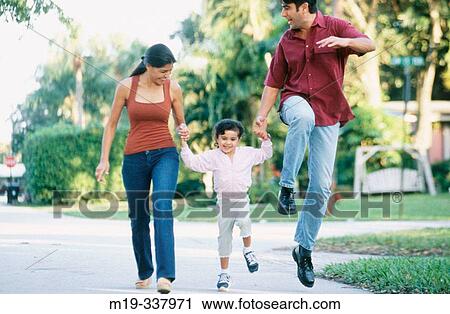 Stock Image - Mom and Dad running and holding up daughter. Fotosearch