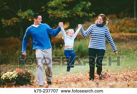 Mom and Dad running and holding up daughter View Large Photo Image Stock Photo - Mom and Dad running and holding up daughter. Fotosearch