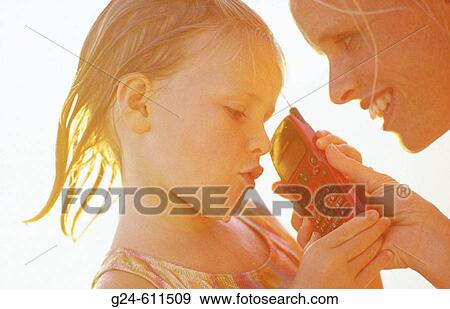 Mom and daughter having phone conversartion at the beach View Large Photo Image Stock Photo - Mom and daughter having phone conversartion at the beach. Fotosearch