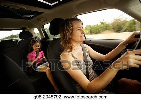 Stock Image - Mom and daughter into a car.. Fotosearch