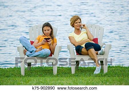 mom and daughter on cell phones View Large Photo Image Stock Image - mom and daughter on cell phones. Fotosearch