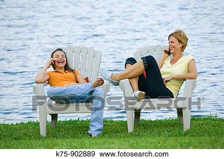 Stock Photo - mom and daughter on cell phones. Fotosearch