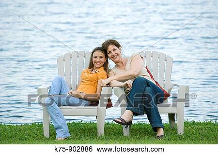 mom and daughter sitting in adirondack chairs lakeside View Large Photo Image Stock Photograph - mom and daughter sitting in adirondack chairs lakeside. Fotosearch