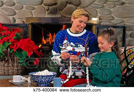 Mom and daughter stringing popcorn for Christmas garland View Large Photo Image Picture - Mom and daughter stringing popcorn for Christmas garland. Fotosearch