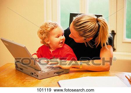 Stock Photo - Mom and toddler son on PC. Fotosearch