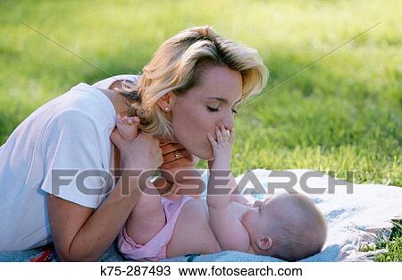 Stock Image - Mom bonding with baby outdoors. Fotosearch