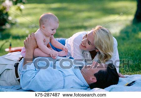 Stock Photo - Mom, dad, and baby bonding. Fotosearch