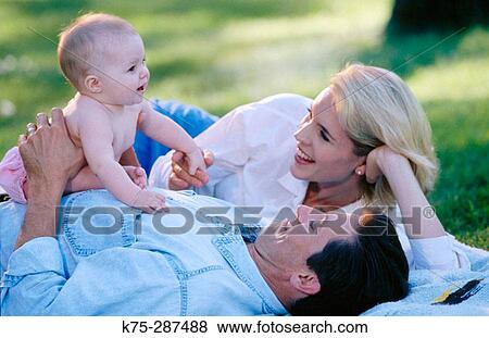Mom, dad, baby on lawn View Large Photo Image Stock Photo - Mom, dad, baby on lawn. Fotosearch