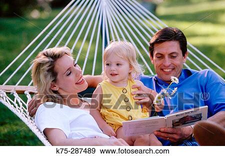 Stock Photo - Mom, dad, daughter in hammock. Fotosearch