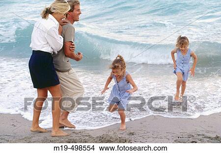 Mom & dad with twin girls at the beach View Large Photo Image Picture - Mom & dad with twin girls at the beach. Fotosearch