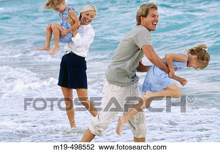 Mom & dad with twin girls at the beach View Large Photo Image Stock Image - Mom & dad with twin girls at the beach. Fotosearch