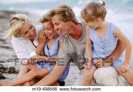 Mom & dad with twin girls at the beach View Large Photo Image Stock Photograph - Mom & dad with twin girls at the beach. Fotosearch