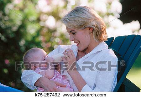 Mom feeding her baby a bottle View Large Photo Image Stock Image - Mom feeding her baby a bottle. Fotosearch