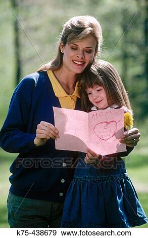 Mom gets a hug and a card from her daughter View Large Photo Image Stock Photo - Mom gets a hug and a card from her daughter. Fotosearch