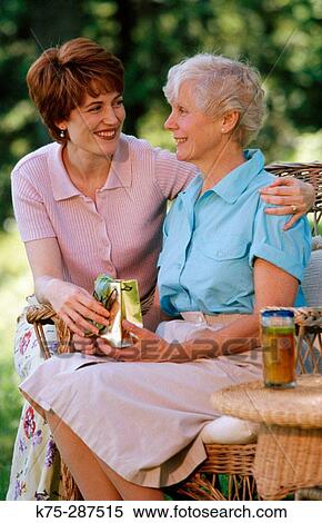 Mom gets a present from her daughter View Large Photo Image Stock Photography - Mom gets a present from her daughter. Fotosearch