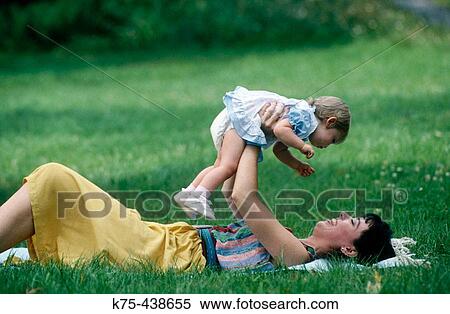 Mom lifting toddler View Large Photo Image Stock Photography - Mom lifting toddler. Fotosearch