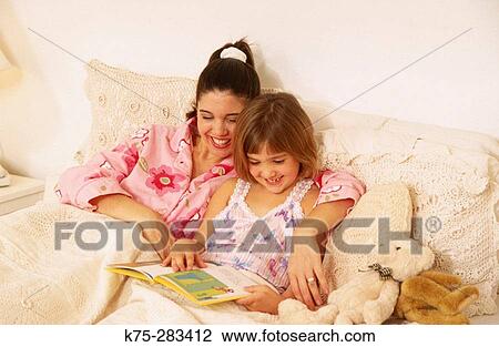 Mom reading to daughter in bed View Large Photo Image Stock Image - Mom reading to daughter in bed. Fotosearch