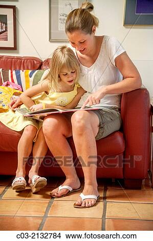 Mom reads aloud to her daughter at home in Laguna Niguel, CA. View Large Photo Image Picture - Mom reads aloud to her daughter at home in Laguna Niguel, CA.. Fotosearch