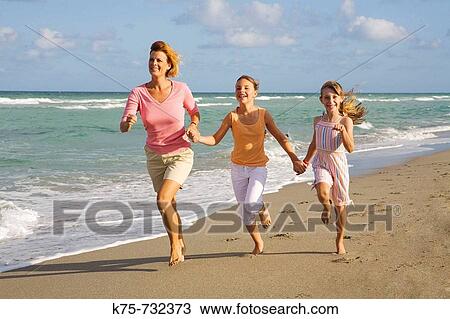 Mom running with young girls at beach View Large Photo Image Stock Image - Mom running with young girls at beach. Fotosearch