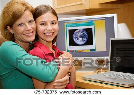 Stock Photography - Mom taking time with daughter at computer. Fotosearch