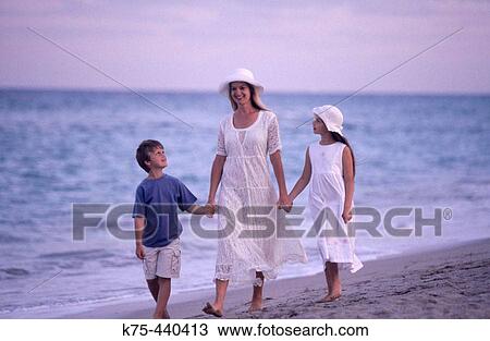 Mom walking hand in hand with her children by the sea View Large Photo Image Stock Image - Mom walking hand in hand with her children by the sea. Fotosearch