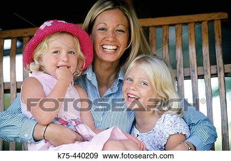 Mom with two young daughters laughing on porch swing View Large Photo Image Stock Photo - Mom with two young daughters laughing on porch swing. Fotosearch