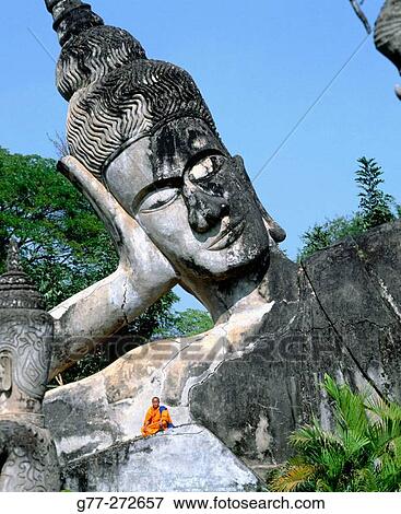 Monk at the giant Buddha, Buddha Park. Vientiane. Laos View Large Photo Image Stock Photo - Monk at the giant Buddha, Buddha Park. Vientiane. Laos. Fotosearch
