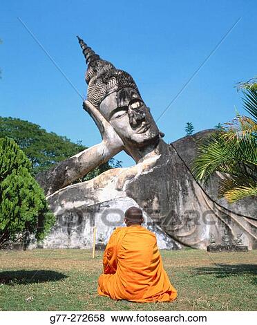Monk at the giant Buddha, Buddha Park. Vientiane. Laos View Large Photo Image Stock Photo - Monk at the giant Buddha, Buddha Park. Vientiane. Laos. Fotosearch