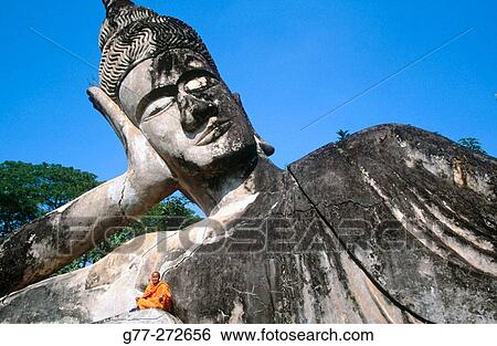 Monk at the giant Buddha, Buddha Park. Vientiane. Laos View Large Photo Image Stock Photograph - Monk at the giant Buddha, Buddha Park. Vientiane. Laos. Fotosearch