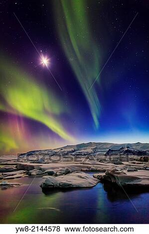 Moon and Aurora Borealis. Northern lights with the moon illuminating the skies and icebergs at the Jokulsarlon Glacial lagoon, Iceland. View Large Photo Image Stock Photo - Moon and Aurora Borealis. Northern lights with the moon illuminating the skies and icebergs at the Jokulsarlon Glacial lagoon, Iceland.. Fotosearch
