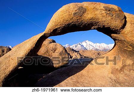 Stock Image - Morning light on Lone Pine Peak in winter through rock arch in the Alabama Hills, Inyo National Forest, Sierra Nevada Mountains, California USA.. Fotosearch