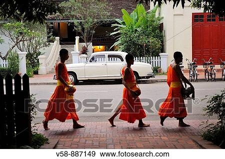 Morning round of buddhist monks begging for alms or Tak Bat, Luang Prabang, Laos View Large Photo Image Stock Photo - Morning round of buddhist monks begging for alms or Tak Bat, Luang Prabang, Laos. Fotosearch
