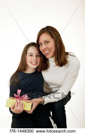 Mother 40s holding wrapped gift given to her by her daughter View Large Photo Image Stock Image - Mother 40s holding wrapped gift given to her by her daughter. Fotosearch