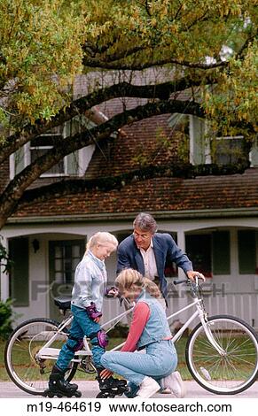 mother adjusts daughter's roller skates, dad watches View Large Photo Image Stock Photo - mother adjusts daughter's roller skates, dad watches. Fotosearch