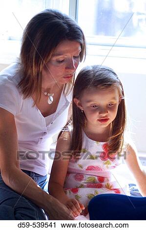 Mother and 4 year old daughter reading a book View Large Photo Image Stock Image - Mother and 4 year old daughter reading a book. Fotosearch